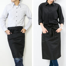 画像をギャラリービューアに読み込む, 明るめのシャツを着てミドル丈サロンエプロンをつける男性と黒いシャツを着てミドル丈サロンエプロンを着た女性
